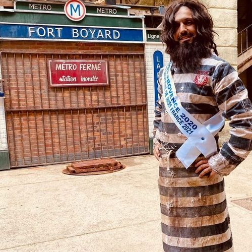 Le Chef Willy en tenue de Miss devant la porte du Métro