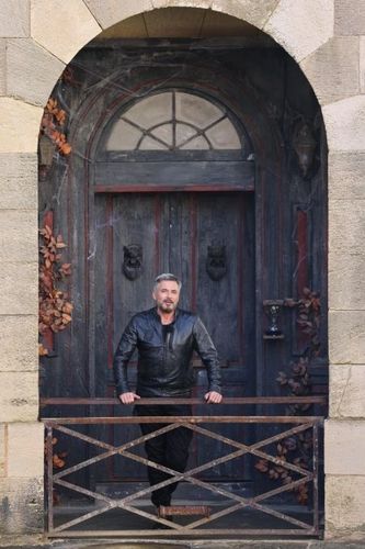 Portrait d'Olivier Minne devant la porte du Manoir