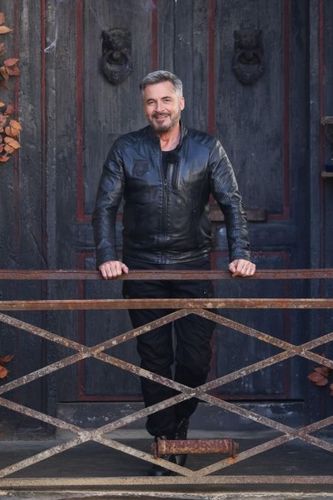 Portrait d'Olivier Minne devant la porte du Manoir