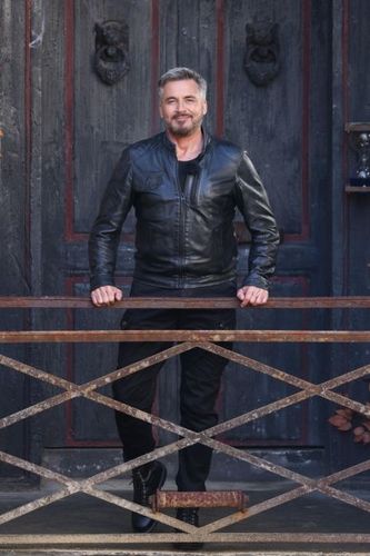 Portrait d'Olivier Minne devant la porte du Manoir